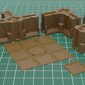 Puede incluir: Un conjunto de piezas de terreno en miniatura marrones para juegos de mesa. El conjunto incluye muros, torres y baldosas con diseños arquitectónicos detallados. Las piezas están dispuestas sobre una superficie de cuadrícula verde.