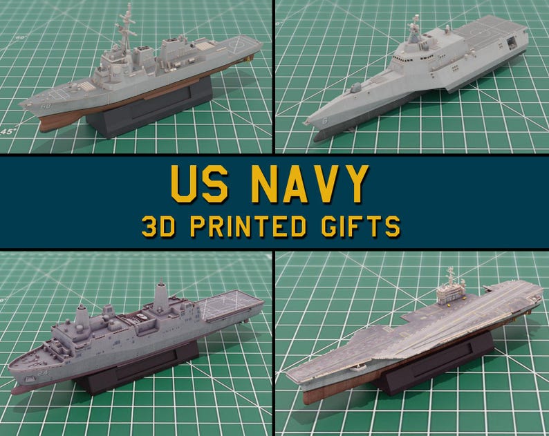May include: Four grey 3D-printed model US Navy ships are shown on a green grid surface. The models have brown and black accents. The text "US NAVY 3D PRINTED GIFTS" is in yellow and white on a dark blue background.