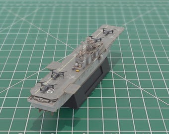 May include: A detailed model of a gray aircraft carrier with several small aircraft on the deck. The model is mounted on a black base and sits on a green grid surface. The number 6 is visible on the deck.