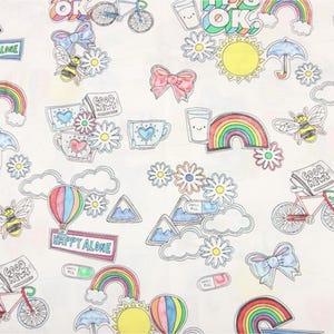 May include: White fabric with a repeating pattern of colorful illustrations. The design includes rainbows, bees, flowers, bicycles, hot air balloons, and text that says "OK", "Good News", "Happy Alone", and "Smile All".