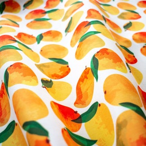 May include: A white fabric with a repeating pattern of yellow and orange mangoes with green leaves.
