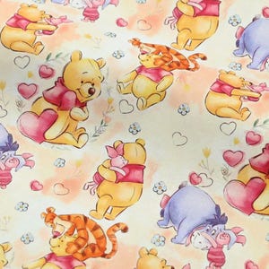 May include: A repeating pattern featuring Winnie the Pooh, Piglet, Tigger, and Eeyore. The characters are in various poses, with hearts and floral accents on a cream-coloured background. The illustrations are in soft, watercolour-like tones.