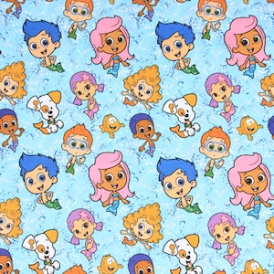 May include: A light blue fabric featuring a repeating pattern of cartoon characters, including merpeople with blue, pink, and orange hair, a white and orange dog, and small yellow fish. The background has a water-like effect.