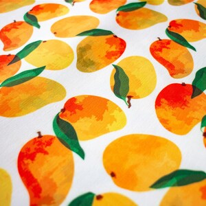 May include: White fabric with a repeating pattern of yellow, orange, and red mangoes with green leaves.