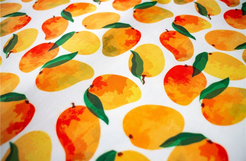 May include: White fabric with a repeating pattern of yellow, orange, and red mangoes with green leaves.