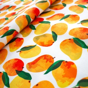May include: White fabric with a repeating pattern of yellow and orange mangoes with green leaves.