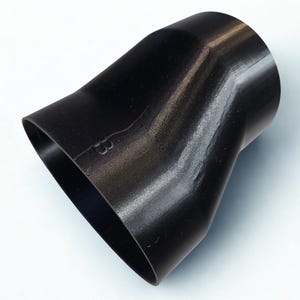 Könnte beinhalten: Ein schwarzes, hohles, konisches Adapterbauteil mit glatter, seidenmatter Oberfläche. Das Objekt verfügt über eine breite, ovale Öffnung an einem Ende, die in eine schmalere, kreisförmige Öffnung am anderen Ende übergeht, mit dem Buchstaben B eingeprägt.