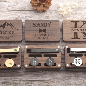 May include: Six wooden boxes with engraved names and dates. Each box contains a tie clip and cufflinks. The boxes are arranged in two rows of three.
