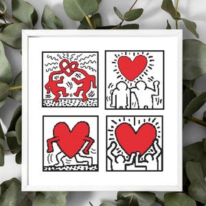 May include: A framed artwork featuring four square panels with Keith Haring-inspired designs. Each panel has a white background with black outlines and red figures, including hearts and dancing figures. The artwork is surrounded by green foliage.