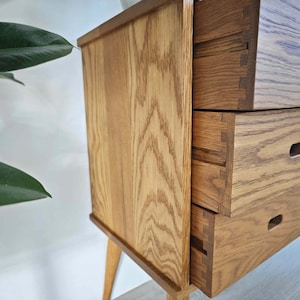 May include: A wooden dresser with three drawers. The drawers have a light wood finish and are made of solid wood. The dresser has a simple design and is perfect for a bedroom or living room.