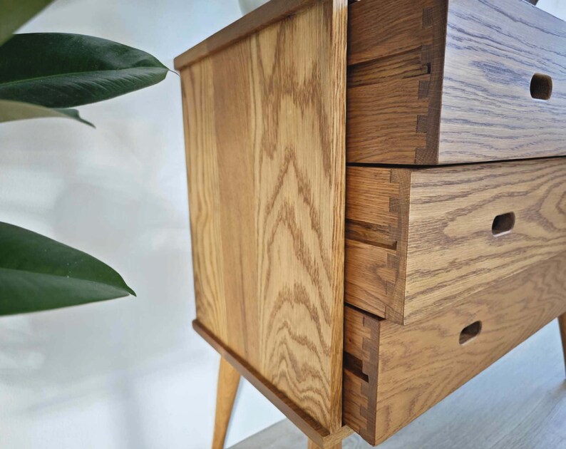 May include: A wooden dresser with three drawers. The drawers have a light wood finish and are made of solid wood. The dresser has a simple design and is perfect for a bedroom or living room.