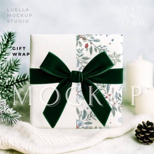 May include: A wrapped gift with a white background and a dark green velvet bow. The gift wrap has a floral and snowflake pattern. The text "GIFT WRAP" is visible on the left side of the image. The text "MOCKUP" is also visible.