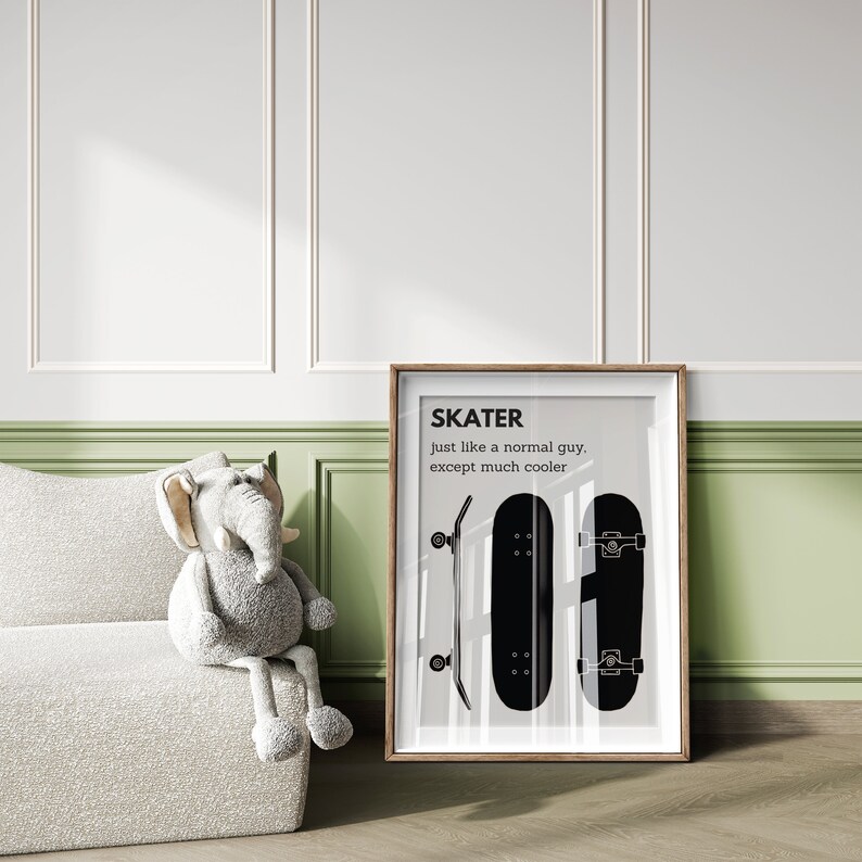 May include: A framed print featuring the word "SKATER" above the phrase "just like a normal guy, except much cooler." The print displays two black skateboards. A stuffed elephant toy sits on a white textured couch.
