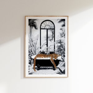May include: A framed wall art print featuring a black and white illustration of a clawfoot bathtub in a lush, tropical setting. A spotted orange and black leopard rests inside the tub, which is surrounded by various plants and a large arched window.