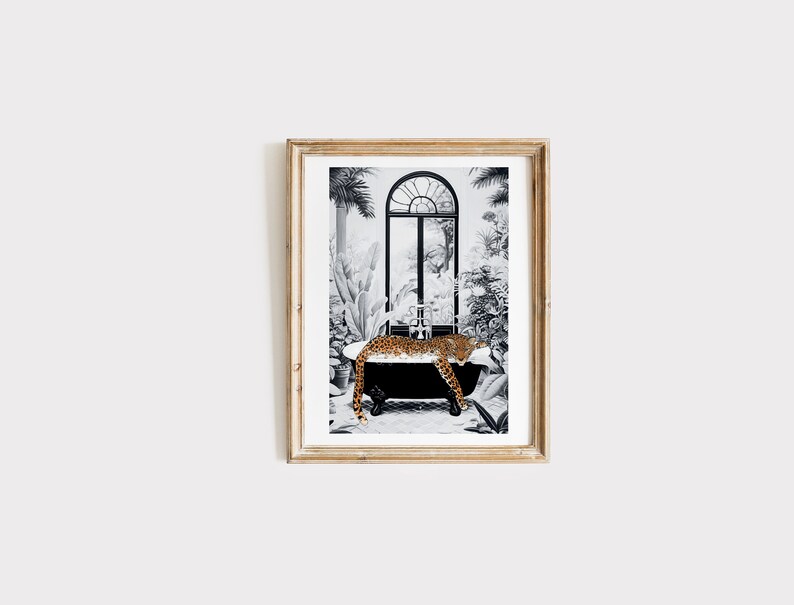 May include: A framed art print featuring a black and white illustration of a leopard resting in a clawfoot bathtub. The scene is set against a backdrop of lush tropical plants and a large arched window, with the leopard's orange and black spotted fur providing a vibrant contrast to the monochrome surroundings.