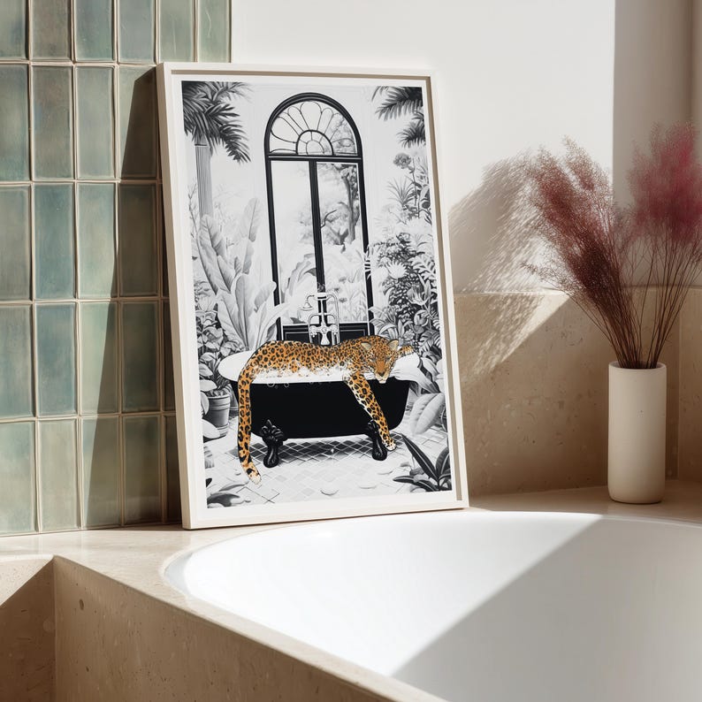 May include: A framed black and white art print featuring a leopard resting in a clawfoot bathtub. The scene includes a large arched window, lush tropical plants, and a tiled floor. The leopard has a spotted coat and is positioned inside the tub.
