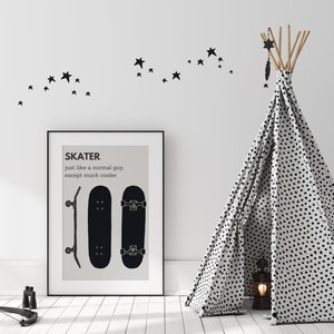 May include: A framed black and white print with the word "SKATER" and two skateboard illustrations. A black and white teepee with a dotted pattern stands to the right. Black star decals are on the white wall.
