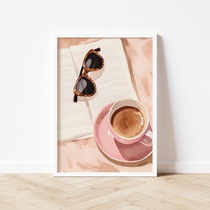 K&ouml;nnte beinhalten: Eine rosa Kaffeetasse mit braunem Kaffee darin, eine Untertasse und eine Sonnenbrille aus Schildpatt auf einem wei&szlig;en und rosa Hintergrund.