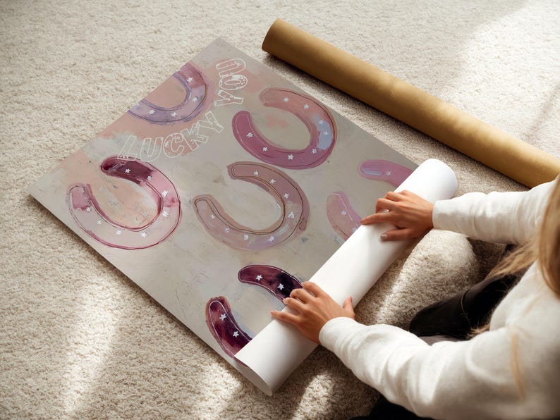 Może przedstawiać: Grafika z ilustracjami podk&oacute;w w odcieniach r&oacute;żu i fioletu, z napisem "LUCKY YOU" w stylu ręcznym. Grafika znajduje się na neutralnym tle, w pobliżu zwinięta tuba na plakat.