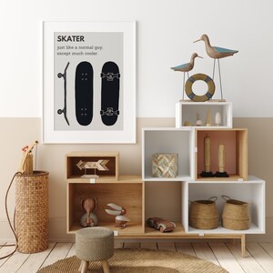 May include: A framed print with the word "SKATER" and a skateboard illustration hangs above a wooden storage unit. The unit displays decorative items, including wooden birds, a life preserver, and woven baskets. A small stool and a woven basket are in the foreground.