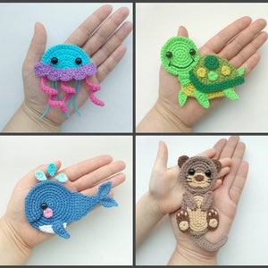 May include: Four crocheted animal and sea creature toys. A purple and pink jellyfish, a green turtle, a blue whale, and a brown otter.