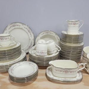 May include: A set of fine china dinnerware with a floral pattern. The set includes plates, bowls, cups, saucers, a creamer, and a gravy boat.