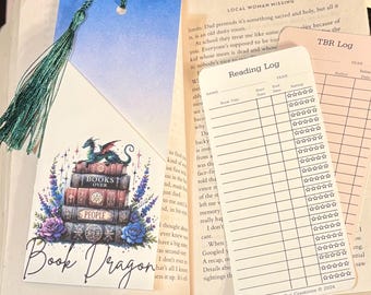 May include: A bookmark featuring a green dragon perched on a stack of books with the words "Books Over People" on the cover of the top book. The bookmark is surrounded by flowers and stars. The text "Book Dragon" is written in cursive at the bottom of the bookmark.