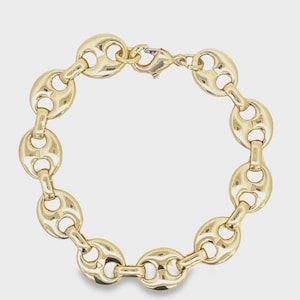 May include: A gold-colored bracelet featuring a chain link design. The links are oval-shaped with a hollowed-out center. The bracelet is secured with a lobster clasp. The jewelry is displayed against a neutral background.
