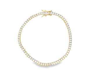 May include: A gold tennis bracelet with a row of clear, round-cut gemstones. The bracelet features a secure clasp. The gemstones are set closely together, creating a continuous sparkle. The bracelet is displayed on a white background.
