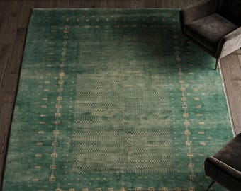 May include: A rectangular, emerald green area rug with a detailed border and central pattern. The rug features a repeating geometric design in a lighter shade of green, creating a textured appearance. The rug is placed on a dark wood floor, with two armchairs visible.