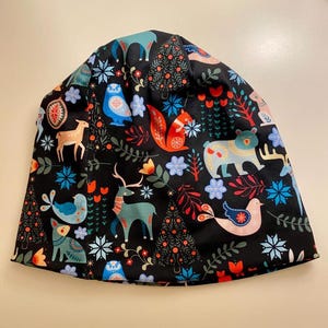 May include: Black beanie with a colorful Scandinavian-inspired pattern featuring animals, trees, and snowflakes.
