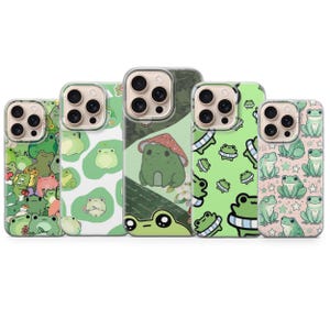 May include: Five smartphone cases arranged in a row, each featuring a unique green frog-themed design. The patterns include various illustrations of frogs, some with mushrooms, stars, or abstract shapes, set against backgrounds of light and dark green.
