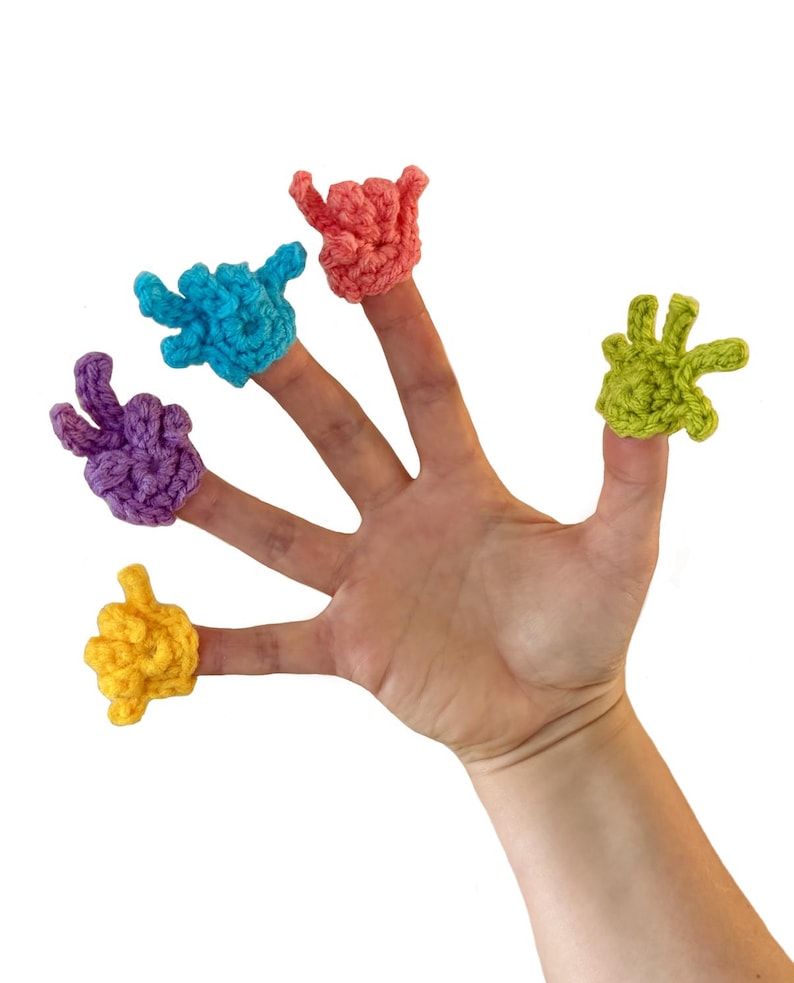 May include: A hand with six colorful, crocheted finger puppets. The puppets are in the shape of hands, each in a different color: yellow, purple, blue, coral, and green. The background is plain white.