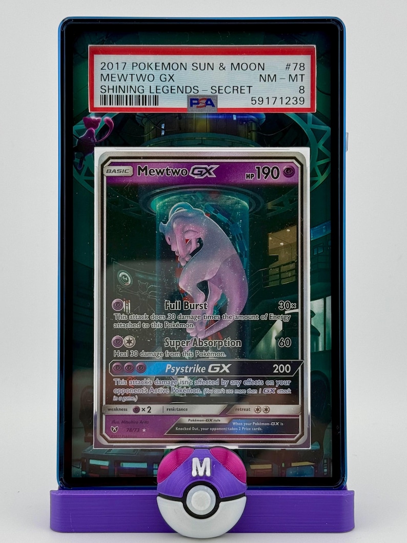 Może przedstawiać: Zklasyfikowana karta kolekcjonerska Pokemon z Mewtwo GX z zestawu Shining Legends. Karta jest w stanie prawie idealnym i ma ocenę PSA 8. Karta jest otoczona niebieskim i fioletowym etui ochronnym.