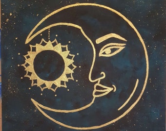 Pode incluir: Uma lua crescente dourada com um rosto humano estilizado e um sol com um design de mandala em um fundo azul escuro com manchas douradas.