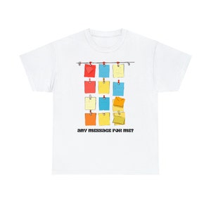 Peut inclure: T-shirt blanc avec un motif de notes autocollantes colorées accrochées à une ficelle avec le texte "any message for me?" imprimé en dessous.
