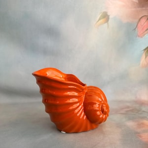 May include: A white ceramic mug with a black handle and the text "But First, Coffee" in a black, bold font. The mug is sitting on a white surface.