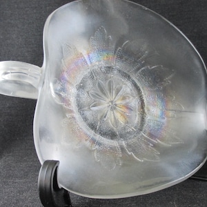 May include: A white ceramic mug with a black handle and the text "But First, Coffee" in a bold, black font. The mug is set against a neutral background, highlighting its simple design.