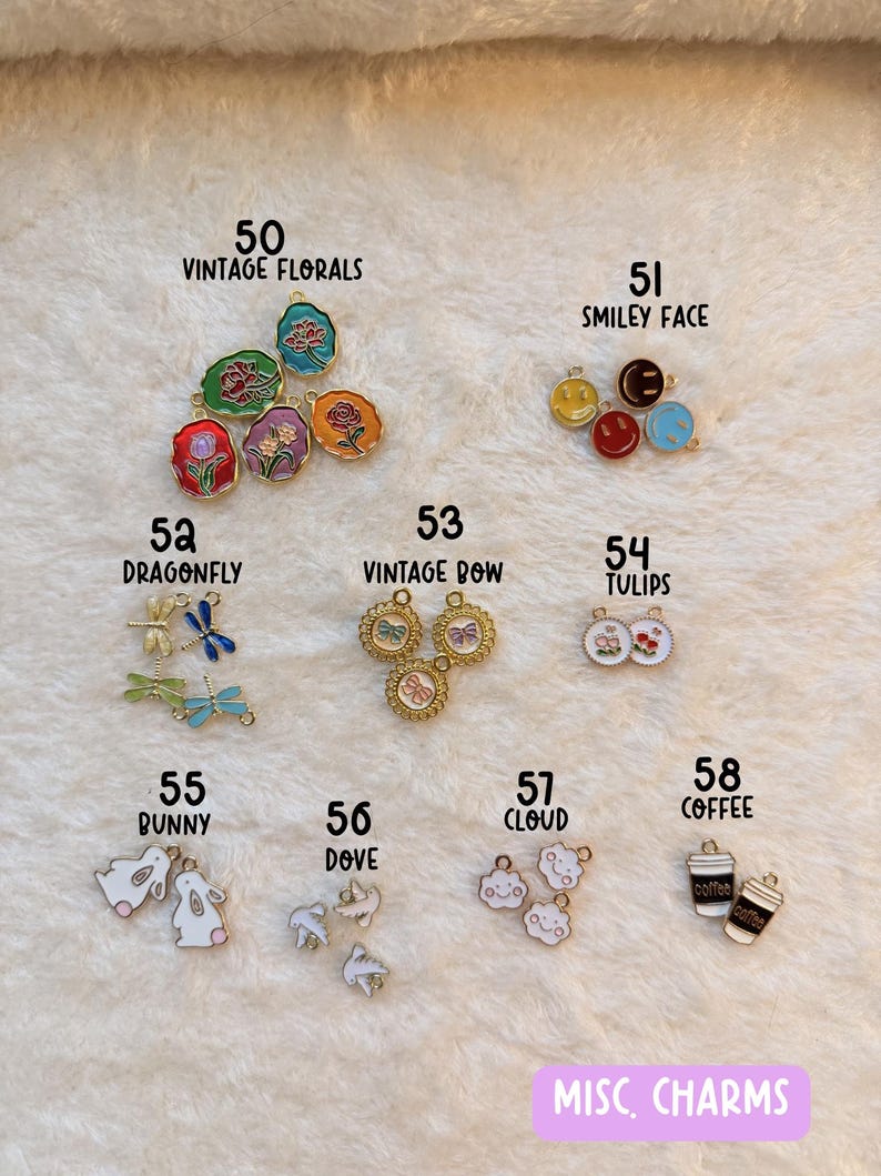 May include: A collection of small, colorful charms with various designs, including flowers, smiley faces, dragonflies, bows, tulips, bunnies, doves, clouds, and coffee cups. The text "MISC. CHARMS" is visible at the bottom.