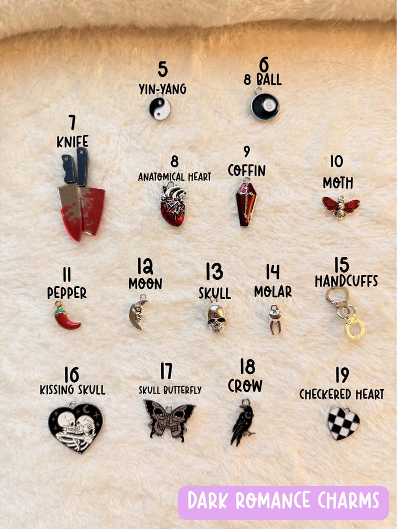 May include: A collection of dark romance charms, including a yin-yang symbol, an 8-ball, a knife, an anatomical heart, a coffin, a moth, a pepper, a moon, a skull, a molar, handcuffs, a kissing skull, a skull butterfly, a crow, and a checkered heart.