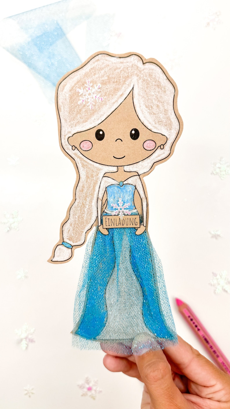May include: A paper craft of a cartoon princess wearing a blue dress with a snowflake design. She is holding a sign that says "Einladung" which is German for "Invitation".
