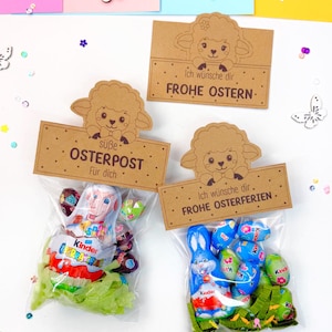 Puede incluir: Dos bolsas de papel marrón con un diseño de cordero y el texto "Ich wünsche dir FROHE OSTERN" y "Ich wünsche dir FROHE OSTERFERIEN". Las bolsas están llenas de huevos de Pascua de chocolate y dulces.