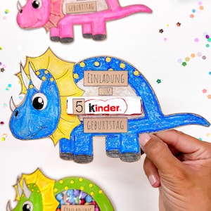 Pu&ograve; includere: Tre inviti di cartone a forma di dinosauro colorati con una finestra ritagliata per leccornie. Il dinosauro rosa dice "Einladung zum Geburtstag", il dinosauro blu dice "Einladung zum 5 Kinder. Geburtstag", e il dinosauro verde dice "Einladung".