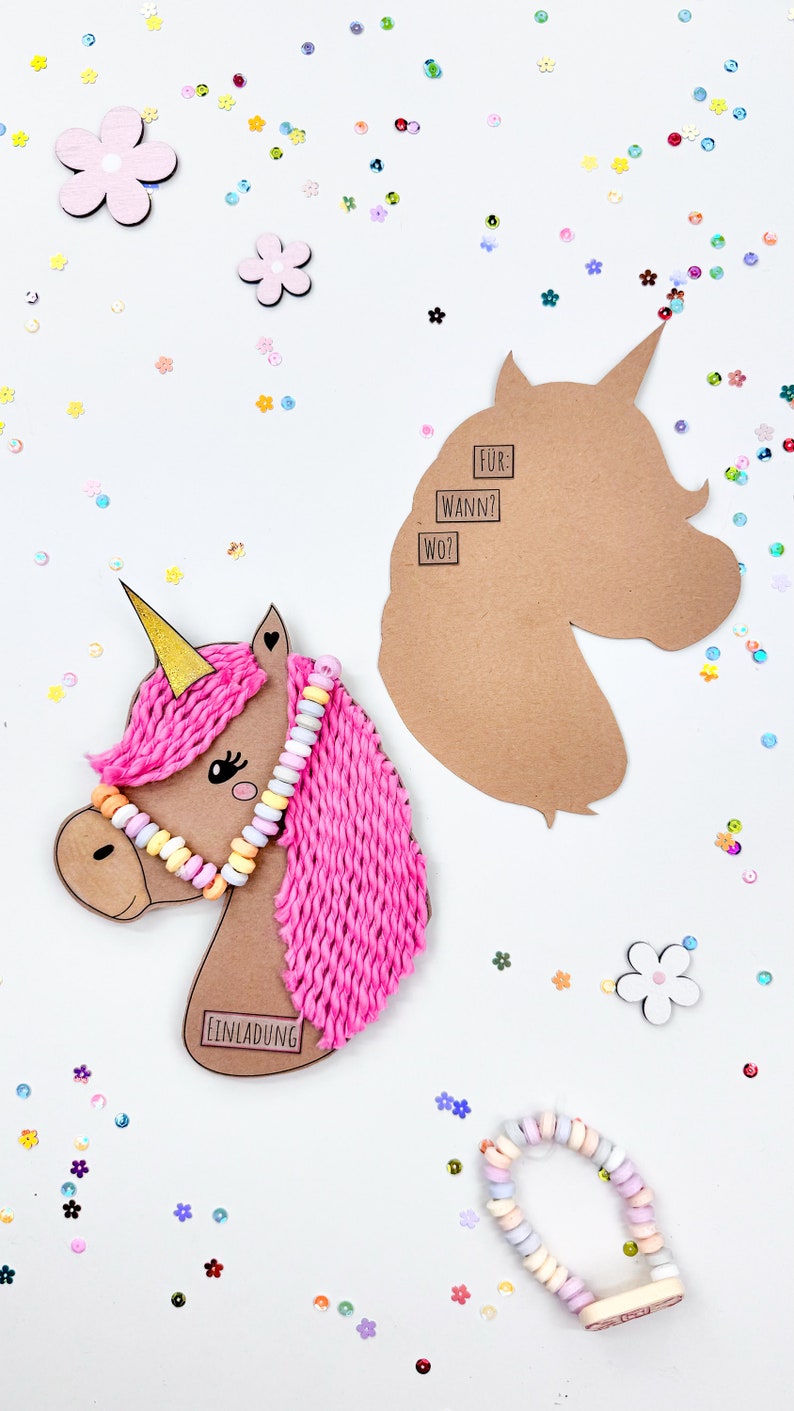 Puede incluir: Una manualidad de unicornio rosa con un cuerno dorado, un collar de caramelos y una crin de hilo rosa. El unicornio est&aacute; sobre un fondo blanco con confeti de colores. El texto "EINLADUNG" est&aacute; en el cuerpo del unicornio. Un recorte separado de cabeza de unicornio de papel marr&oacute;n est&aacute; en el lado derecho de la imagen con el texto "F&Uuml;R: WANN? WO?" en &eacute;l.