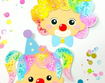 May include: Two colorful paper clown masks with glitter hair, red noses, and bow ties. The masks are on a white background with confetti.