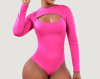 Op de afbeelding: Een felroze bodysuit met lange mouwen en een sleutelgatsnit bij de borst. Het nauwsluitende kledingstuk is gemaakt van een gladde, effen stof. De bodysuit is een eendelig kledingstuk.