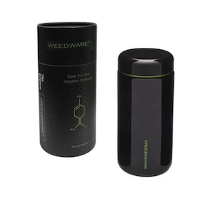 Puede incluir: Tarro de vidrio negro con tapa verde y el texto "WEEDWARE" impreso en el lateral. El tarro está sobre una superficie blanca.
