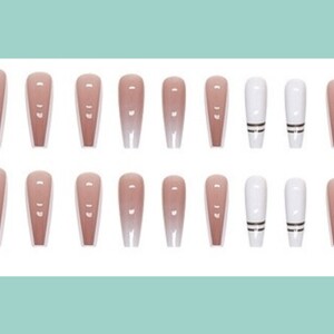 May include: Set of 20 false nails in various nude and white shades. The set includes two nails with black and white stripes.