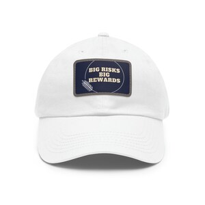 May include: White baseball cap with a navy blue patch that says "BIG RISKS BIG REWARDS" in a circle with a small leaf design.