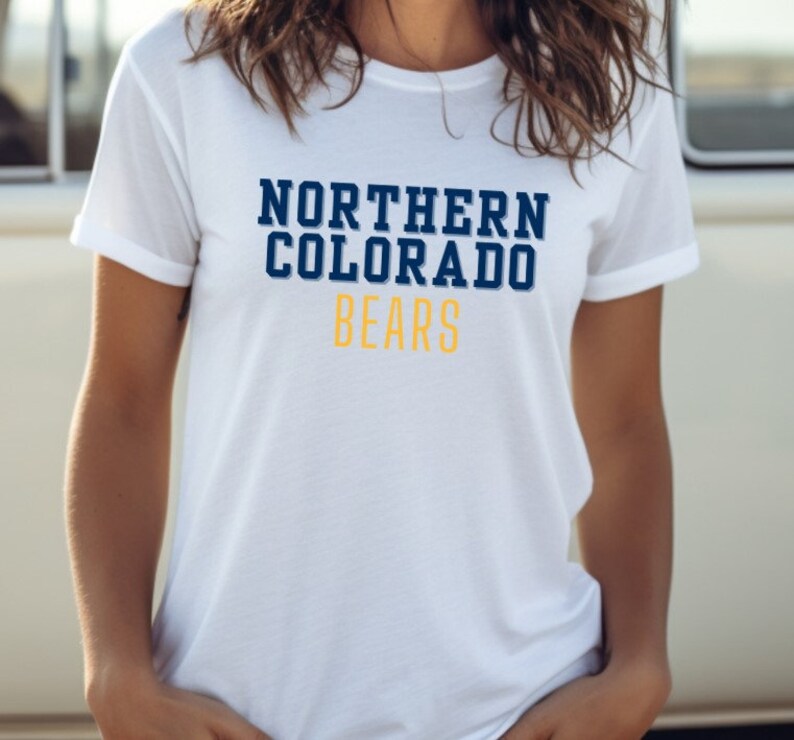 Puede incluir: Camiseta blanca con un gr&aacute;fico azul marino y dorado que dice "NORTHERN COLORADO BEARS"